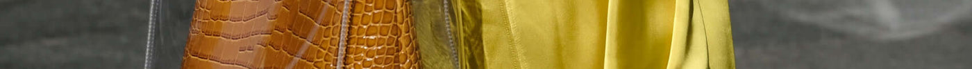 A fashion-forward individual showcasing a chic transparent bag with a luxurious croc embossed handle, embodying technology in modern fashion brands.