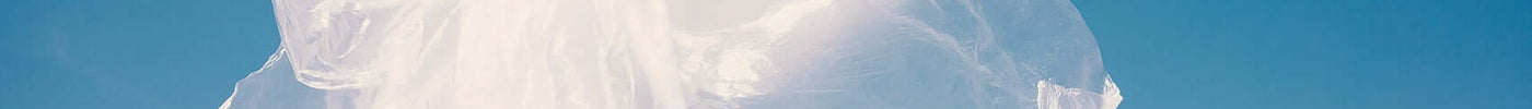 A model showcasing a flowing white garment, symbolizing digital innovation in fashion against a clear blue sky.
