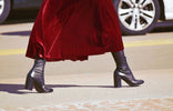 sustainable fashion leader MaisonGrozavu showcasing chic velvet skirt and stylish black heeled boots.