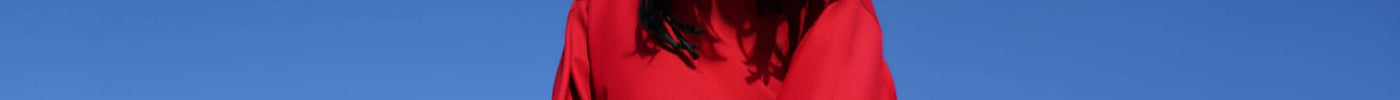 Bold red outfit in contemporary fashion showcasing problem solving styles in contemporary fashion under a blue sky.