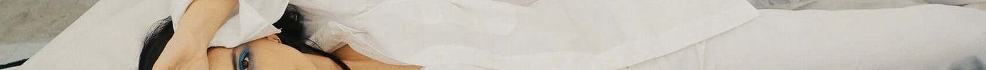 two women laying down wearing white dress shirts