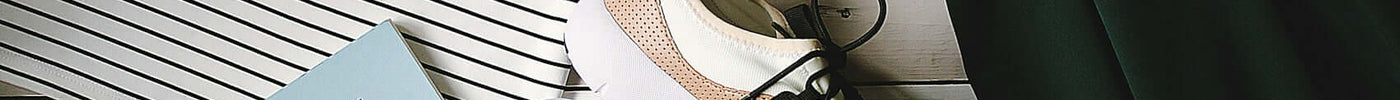 pair of white-and-black low-top sneakers near black skirt on brown clothes hanger top view photography