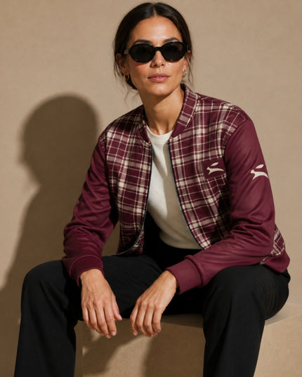 Model seated in the studio wearing the Heritage Tartan Bomber in Bordeaux open