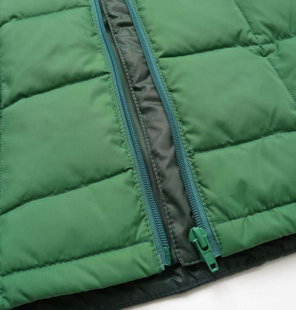 Close-up of green fabric texture and zipper on Color-Block Down Jacket – Loose Fit, showcasing its warmth and style.