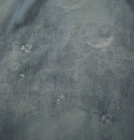 Close-up of the fabric texture of the Letter Applique Washed Hoodie – Loose Fit, showcasing distressed detailing and a faded look.