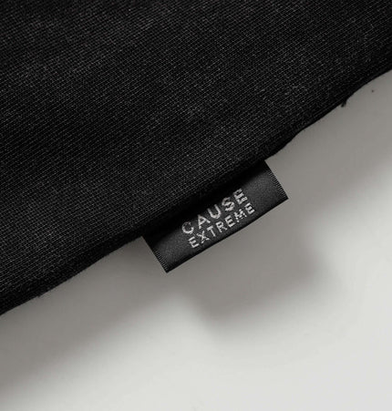Washed Spliced Distressed TShirt – Loose Fit label showing CAUSE EXTREME branding on a black fabric background.