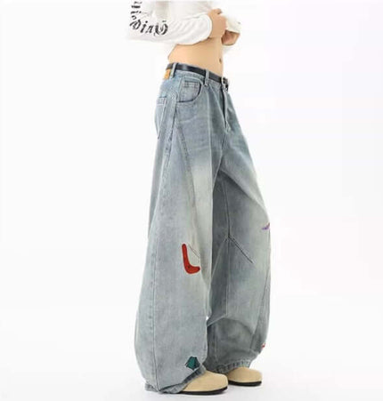 Embroidered Patchwork Denim Pants featuring playful designs and a loose fit for casual streetwear outfits.