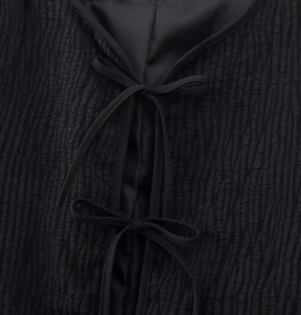 Fur Cuff Single Breasted Jacket showcasing a textured black fabric with ties at the neckline, emphasizing elegant design.