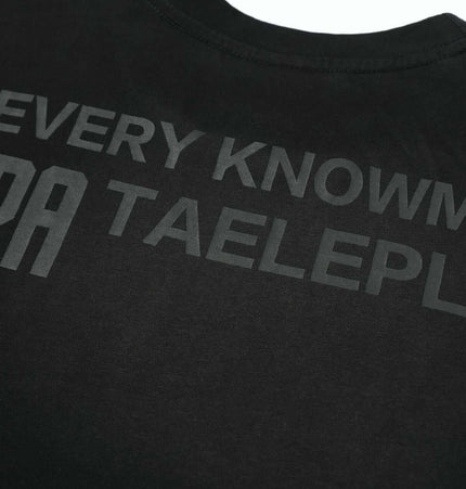 Washed Spray Print TShirt – Loose Fit showcasing printed text design on a black fabric surface.