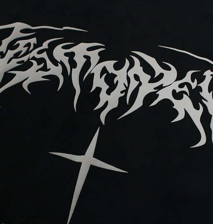 Close-up of intricate white graphic design on black fabric featuring stylized lettering and a cross.