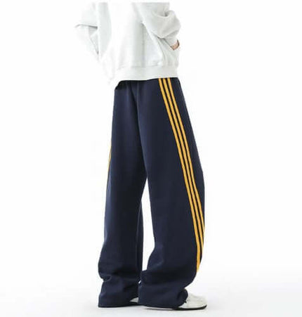 Heavyweight Three-Stripe Pants - Loose Fit showcased in navy with bold yellow stripes, offering comfort and style.