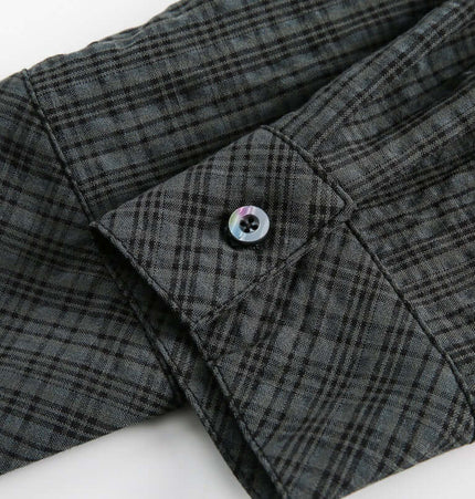 Close-up of the cuff and button detail of the Color Block Plaid Shirt – Loose Fit in dark green plaid pattern.