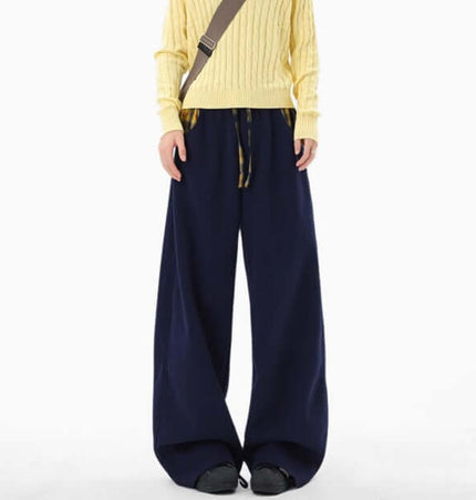 Loose Wide-Leg Sweatpants in navy worn with a yellow sweater, showcasing a relaxed streetwear style.