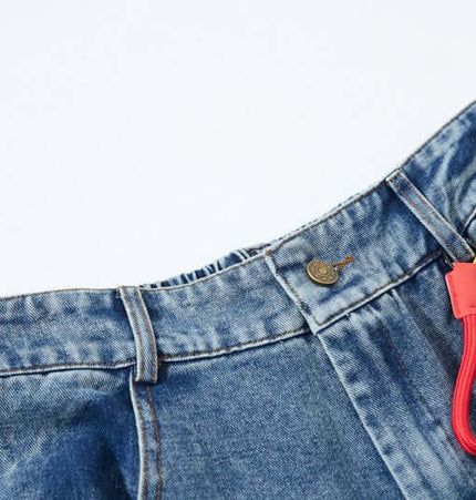 Close-up of Cartoon Patch College Denim Pants showcasing the waistband and cartoon keychain.