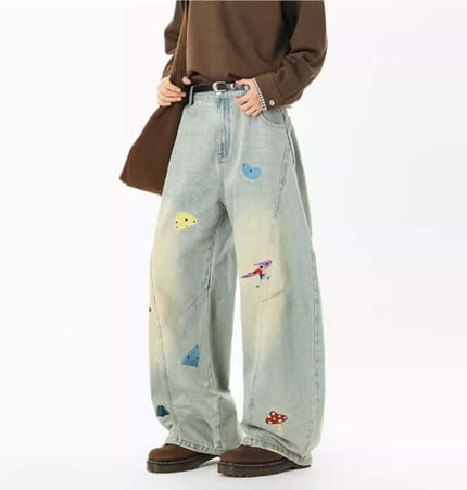 Embroidered Patchwork Denim Pants showcasing playful urban style with a relaxed fit and colorful patchwork details.