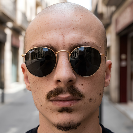 Close-up of a man with a bald head wearing sunglasses, embodying urban elegance and contemporary style.