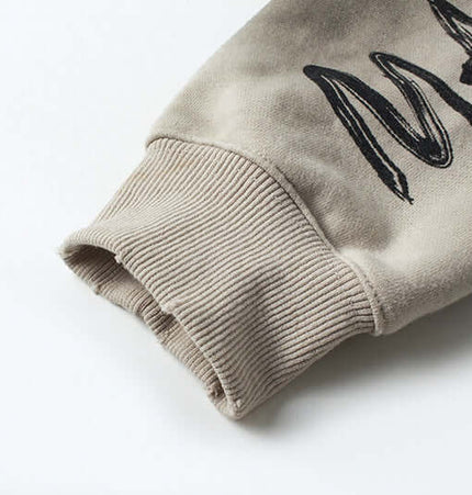 Close-up of sleeve detail on Retro Patchwork Zip Up Hoodie – Loose Fit showcasing ribbed cuff and embroidered design.