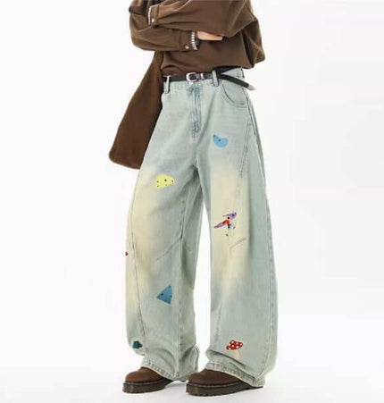Embroidered Patchwork Denim Pants featuring playful designs and a loose fit for trendy streetwear style.
