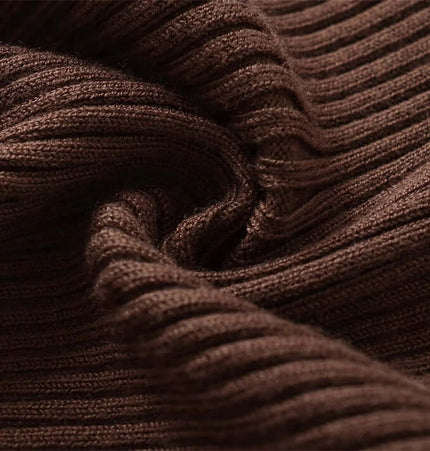 Close-up of soft, brown ribbed fabric showcasing the texture of the Metal Knot Hollow-Out Flare Sleeve Knit Top.