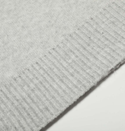 Close-up of the ribbed hem of the Semi-High Neck Simple Knit Sweater in soft gray fabric.