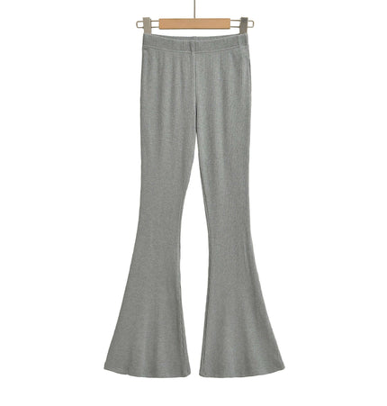 Slim Fit Low Waist Slightly Flared Pants in grey hanging on a wooden hanger.