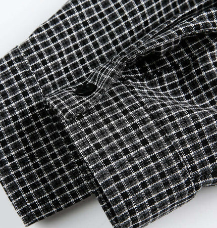 Checkered Patchwork Shirt - Loose Fit close-up of the fabric with button detail in a black and white checkered pattern.