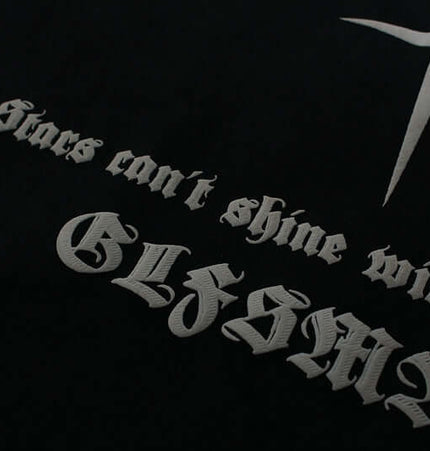 Close-up of fabric featuring text, 'Stars can't shine without GLFSMA', showcasing unique lettering style.