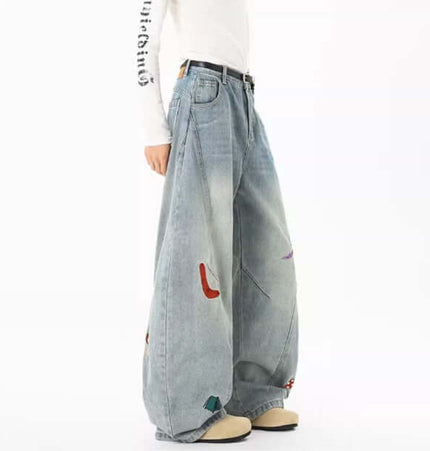 Embroidered Patchwork Denim Pants featuring oversized fit and playful urban style, perfect for streetwear.