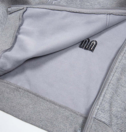 Interior view of the Distressed Letter Zip Hoodie - Loose Fit showcasing soft fabric and embroidery details.