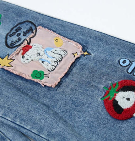 Close-up of cartoon patches on Cartoon Patch College Denim Pants featuring playful embroidery designs.