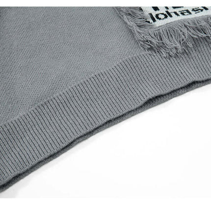 Close-up view of the hem and fringe detail on the Fringe Patchwork Knit Sweater – Loose Fit.