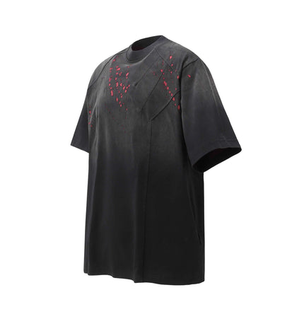 Retro Splatter Print TShirt – Loose Fit showcasing a washed, faded splatter design in black and red.
