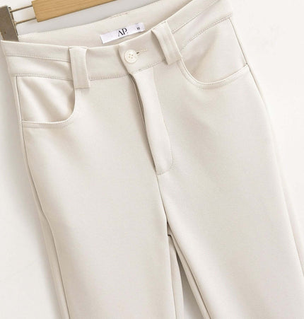 High Elastic Micro Flare Casual Pants in a smooth, light-colored fabric hanging on a wooden hanger.