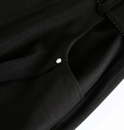 Close-up of the fabric detail on Wide Leg Pleated Plaid Trousers showcasing the button and soft texture.