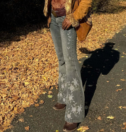 Woman wearing Retro Washed Slim Micro Flared Pants with floral details in autumn setting.