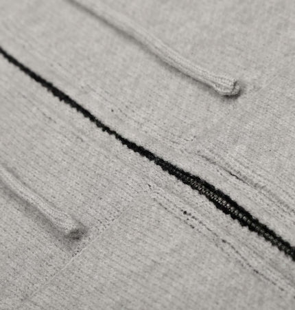Close-up of the Letter Jacquard Knit Hoodie – Loose Fit showcasing soft gray fabric and bold letter patterns.