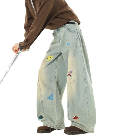Person wearing Embroidered Patchwork Denim Pants with playful designs and a loose fit for streetwear style.