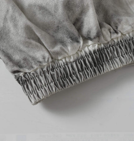 Detail of the Spray Paint Spliced Jacket – Casual Fit showing elastic waistband and unique fabric texture.