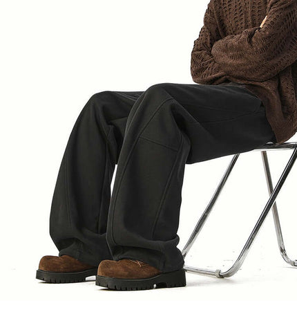 Person wearing Heavyweight Wide-Leg Pants - Loose Fit, seated on a chair with a stylish outfit.