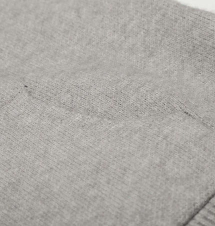Close-up of the soft gray fabric and pocket detail from the Letter Jacquard Knit Hoodie – Loose Fit.