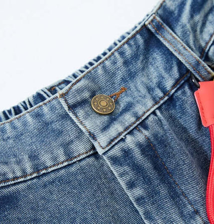Close-up of the top button on Cartoon Patch College Denim Pants with colorful cartoon keychain.