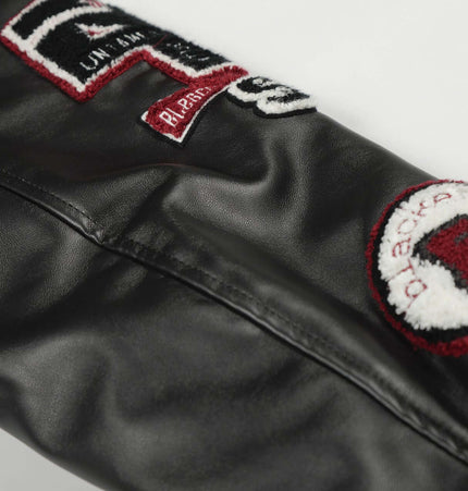 Heavy Embroidery Baseball Jacket – Thick Fit showcasing detailed patches and embroidery on a sleek black sleeve.