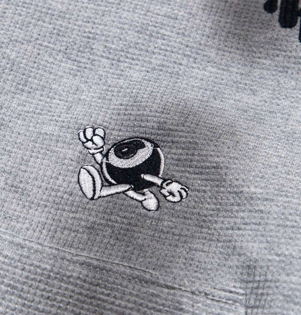 Distressed Letter Zip Hoodie - Loose Fit featuring playful embroidered character detail on grey fabric.