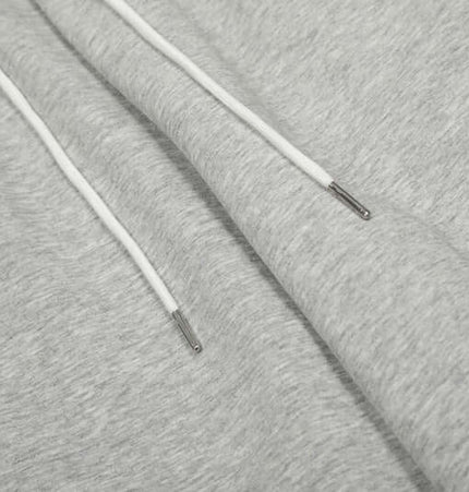 Close-up of Towel Embroidery Heart Sweatpants showcasing soft gray fabric and white drawstrings.