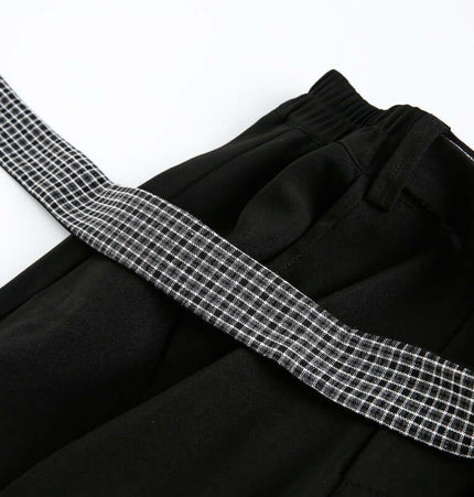 Close-up of the Wide Leg Pleated Plaid Trousers featuring a plaid ribbon detail and elastic waistband.