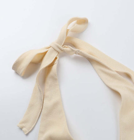 Close-up of the silk ribbon tie of the Split Neck Suspender Top – Slim Fit in cream color.