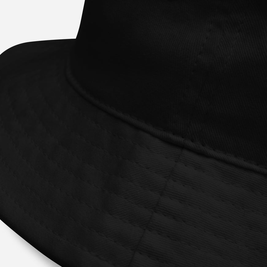 Close-up of the embroidered Grozavu hare on the black bucket hat
