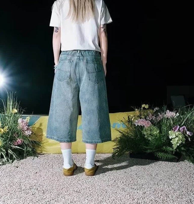 Person wearing Cartoon Dog Embroidered Denim Shorts featuring a trendy washed blue finish and relaxed fit.