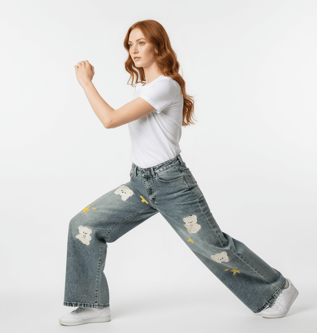 Woman wearing Casual Cartoon Embroidered Denim Pants with cartoon embroidery and distressed details.