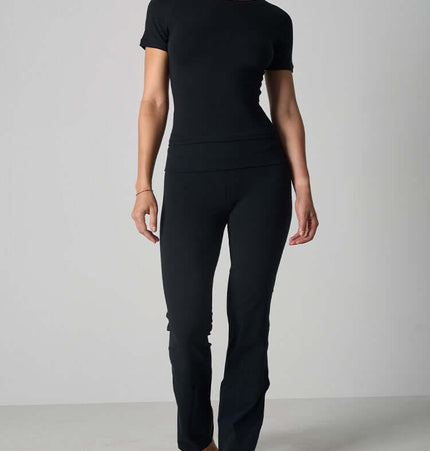 Casual Fit Cotton Jersey Yoga Set worn by a woman, showcasing a short sleeve crop top and high-waist flare pants.